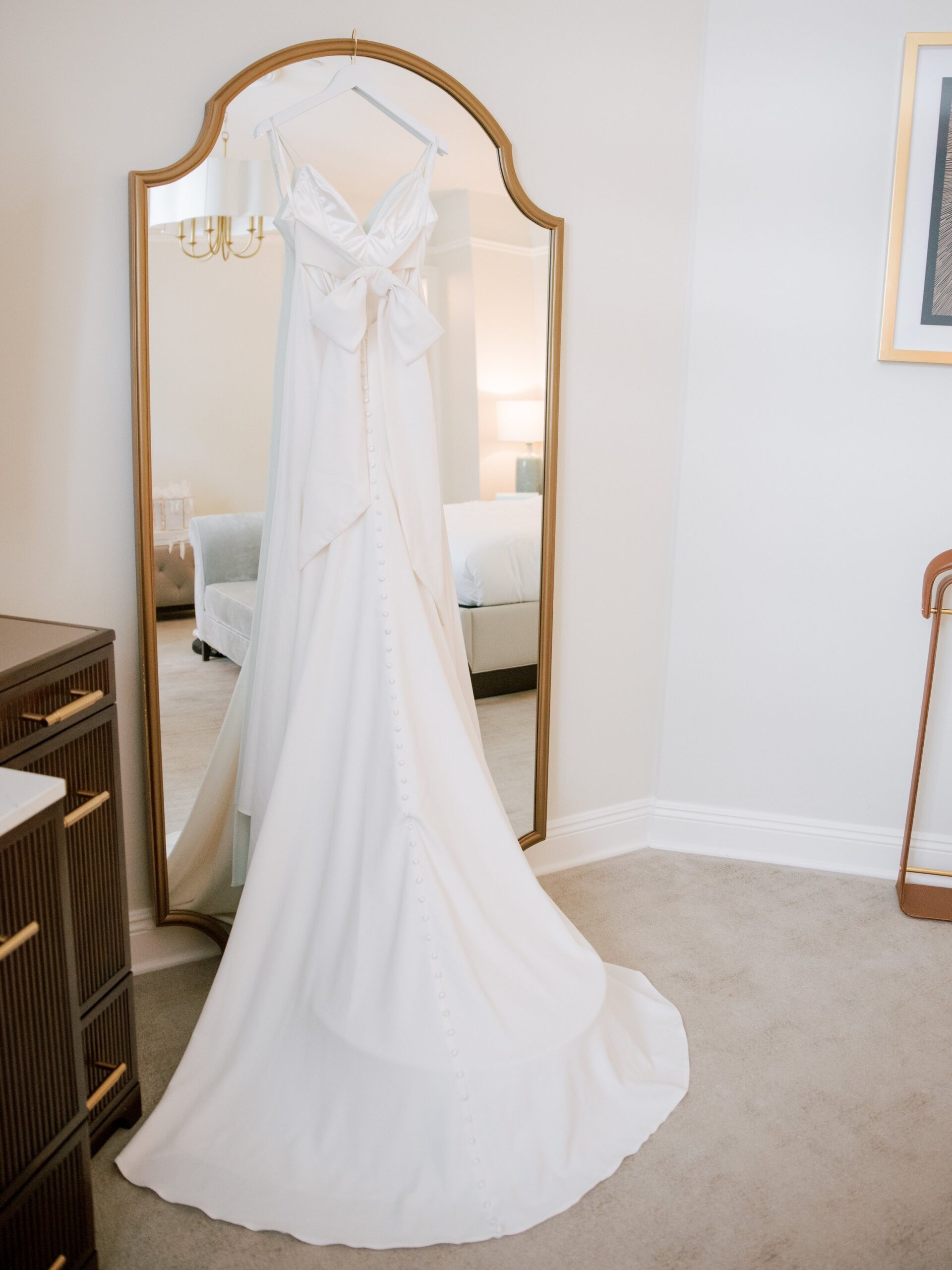 wedding dress hanging on mirror